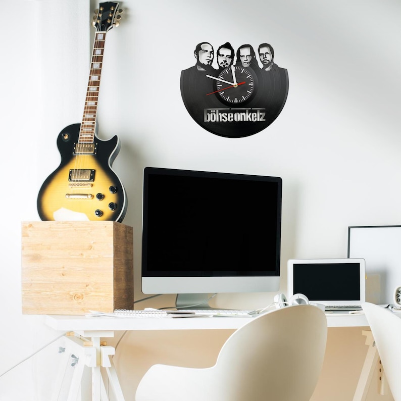 Böhse Onkelz vinyl wall clock hanging in a creative workspace with guitar and computer, ideal for a music-themed interior.