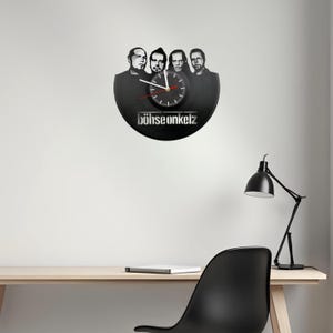 Böhse Onkelz vinyl record clock with band portrait cutout, silent quartz clock movement, and silkscreen dial illustrated with feature icons.