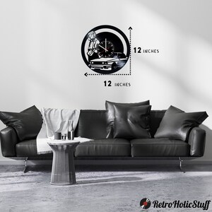 May include: Black vinyl record clock featuring a silhouette of a person sitting in a car. The clock is 12 inches in diameter.