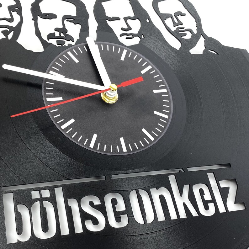 Close-up of Böhse Onkelz vinyl record clock showing detailed cutout portraits of band members above the central clock face.