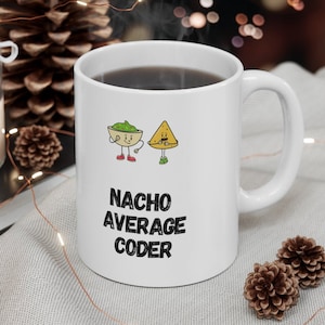 May include: White ceramic coffee mug with a black and white graphic of a nacho chip and a bowl of salsa with the text "Nacho Average Coder".