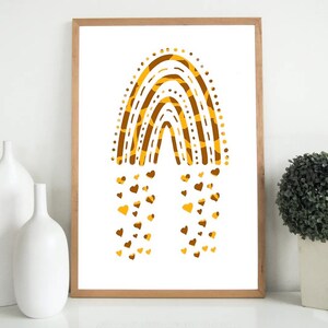 May include: A framed art print featuring a stylized rainbow design in shades of brown and yellow. The rainbow is composed of layered arches with a dotted border and a textured pattern. Small heart shapes cascade from the bottom of the rainbow.