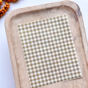 May include: A brown and white gingham patterned square on a wooden tray.