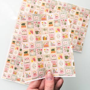 May include: A rectangular sheet of paper featuring a repeating grid pattern of small squares. Each square contains illustrations of books, teacups, candles, and floral arrangements in soft pastel shades of pink, green, yellow, and cream.