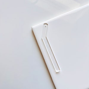 May include: A white, rectangular, blank card with a clear plastic corner protector.