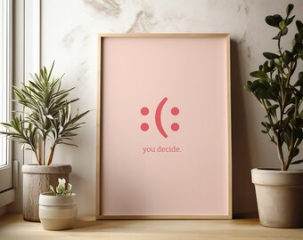 Könnte beinhalten: Ein gerahmter Druck mit rosa Hintergrund und einem roten Smiley mit einem Stirnrunzeln. Der Text "you decide." befindet sich unter dem Smiley.