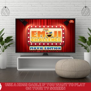 May include: A television screen displaying the game "The Emoji Challenge: Movie Edition". The screen is on a white shelf with a light brown ottoman in front of it. The text "USE A HDMI CABLE IF YOU WANT TO PLAY ON YOUR TV SCREEN" is at the bottom of the image.