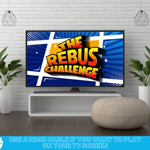 May include: A television screen displaying a colorful graphic with the text "The Rebus Challenge". The screen is on a white shelf with a light brown ottoman in front of it. The text "USE A HDMI CABLE IF YOU WANT TO PLAY ON YOUR TV SCREEN" is at the bottom of the image.