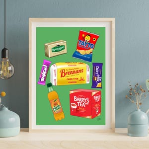 Może przedstawiać: Oprawiony wydruk artystyczny na zielonym tle z ilustracjami irlandzkich produktów spożywczych, w tym masła Kerrygold, chipsów Tayto, chleba Brennan's, batonika Cadbury Snack, batonika Cadbury Dairy Milk, butelki Club Orange oraz pudełka herbaty Barry's.