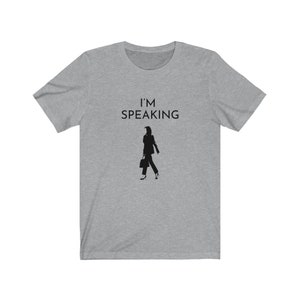 May include: A heather grey t-shirt with the text "I'M SPEAKING" and a silhouette of a woman walking with a briefcase.