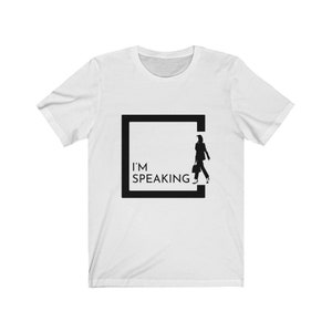May include: White t-shirt with a black square graphic featuring a silhouette of a person walking out of the square. The text "I'M SPEAKING" is inside the square.