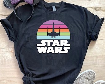 May include: Black t-shirt with a retro sunset graphic and the text "STAR WARS" in white. The graphic features a silhouette of a spaceship.