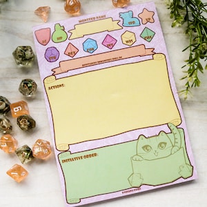 May include: A pink and green monster tracker sheet with a cat peeking out of the bottom. The sheet has spaces for monster name, AC, HP, STR, DEX, CON, INT, WIS, CHA, SPD, XP, actions, and initiative order.