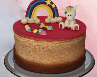 Decoración comestible para tarta de unicornio con arcoíris, hecha de chocolate blanco de colores.