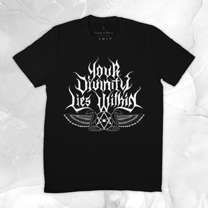 May include: Black t-shirt with a white graphic design that says "Your Divinity Lies Within" with a winged serpent design.