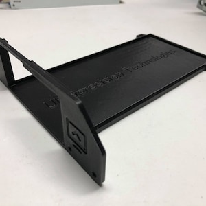 May include: A black plastic 3D printed frame with the text "Ultraprecision Technologies" printed on the top surface.