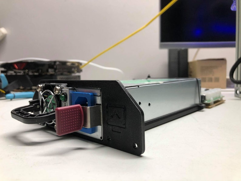 May include: A black server rack with a red button and a blue power connector. The rack has a handle and a fan visible.