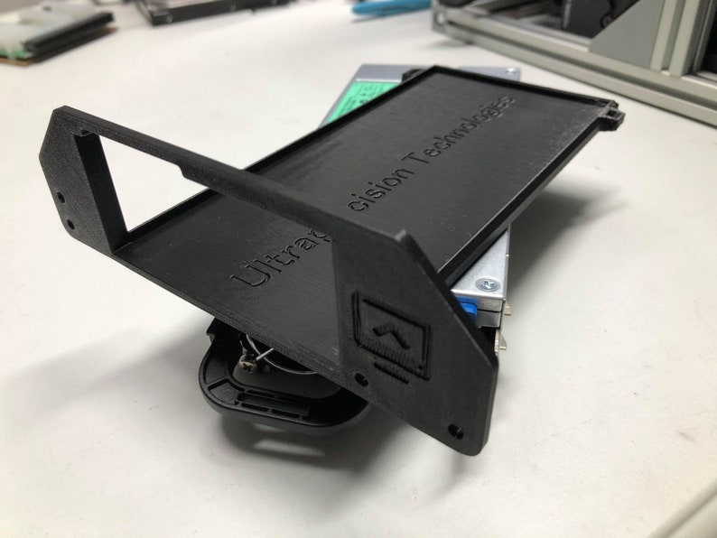 May include: A black 3D printed hard drive enclosure with the text "Ultra Precision Technology" on the top. The enclosure is open and shows a hard drive inside.