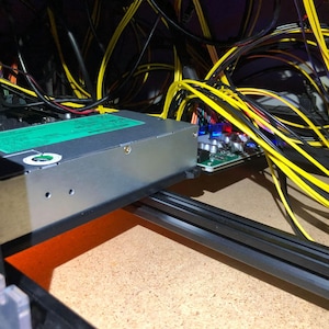 May include: A close-up of a computer's internal components, including a power supply unit, a circuit board, and a tangle of yellow and black wires.