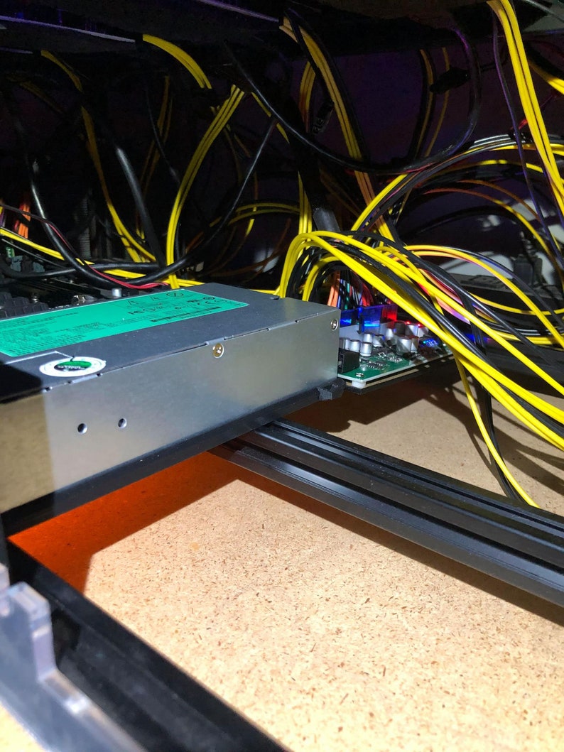 May include: A close-up of a computer's internal components, including a power supply unit, a circuit board, and a tangle of yellow and black wires.
