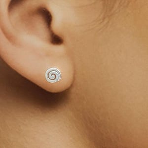 Peut inclure: Une paire de boucles d'oreilles en argent avec un motif en spirale.