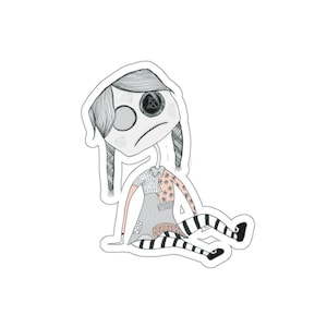 May include: A sticker featuring a sad-faced doll illustration. The doll has pigtails, a patchwork dress, and striped stockings. The design is primarily black and white with touches of pink and floral patterns.