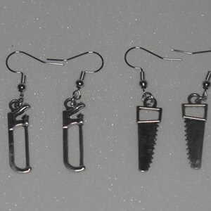 May include: Set of 10 silver tool earrings, including a hammer, wrench, saw, and a saw blade.
