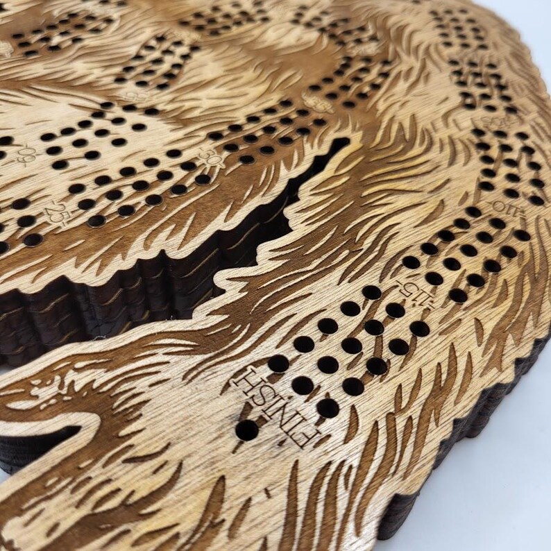 May include: Wooden game board shaped like a bear with black dots and the word "FINISH" engraved on the bottom.
