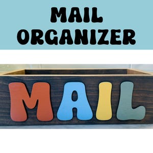 May include: A wooden mail organizer with the word "MAIL" spelled out in colorful letters. The letters are painted in shades of red, blue, yellow, and green.