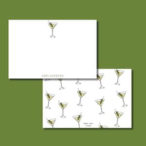 Può includere: Cancelleria bianca con un'illustrazione di martini. Una scheda presenta un singolo martini, l'altra un motivo di martini con olive. I testi "Abby Andrews" e "Annie James Studios" sono visibili.