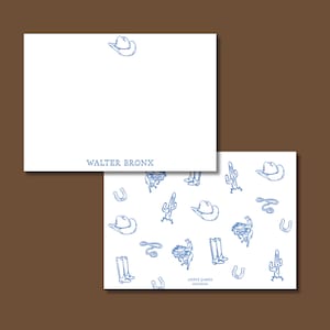 Könnte beinhalten: Weiße Schreibwaren mit blauen Illustrationen zum Thema Cowboy. Eine Karte trägt den Namen "WALTER BRONX" in blauer Schrift. Die andere Karte hat ein Muster aus Cowboyhüten, Stiefeln, Kakteen und Hufeisen.