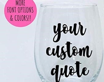 May include: A clear glass wine glass with a black vinyl decal that says "your custom quote".
