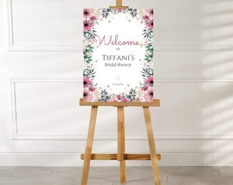 Peut inclure: Une pancarte de bienvenue blanche avec des accents floraux roses et verts. La pancarte indique "Bienvenue au shower nuptial de Tiffany".