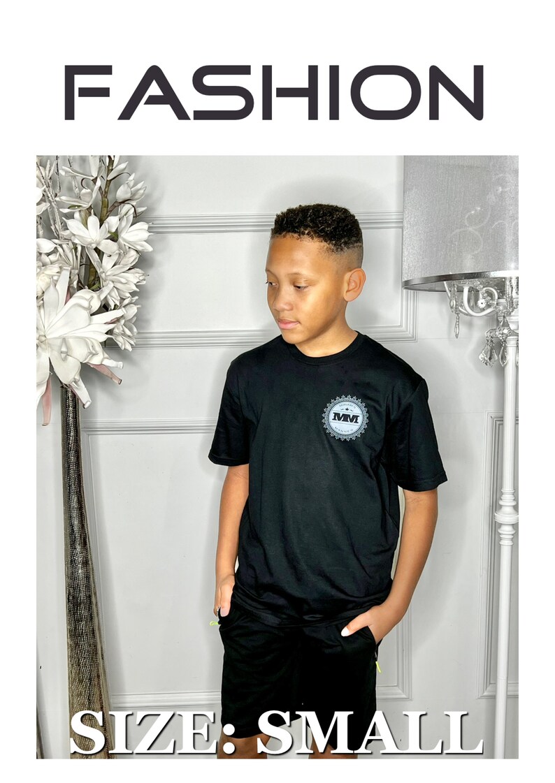 K&ouml;nnte beinhalten: Schwarzes T-Shirt mit einem grauen und wei&szlig;en Logo, auf dem "MM" in einem Kreis steht. Das Shirt wird mit schwarzen Shorts kombiniert. Das Model tr&auml;gt ein schwarzes T-Shirt und schwarze Shorts. Gr&ouml;&szlig;e: Small.