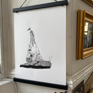 Può includere: Disegno a inchiostro nero e bianco di una lumaca che porta un castello sulla schiena. La lumaca è rivolta verso il lato sinistro dell'immagine. Il castello ha una bandiera in cima. Il disegno è incorniciato in una cornice nera.