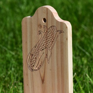 Close up of engraved corn ear in cedar wood.