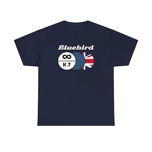 Puede incluir: Una camiseta azul marino con el texto "Bluebird" y un gráfico de tres círculos. Los círculos son blancos, azules y rojo, blanco y azul. El círculo blanco tiene el símbolo del infinito y el texto "K7" en su interior.