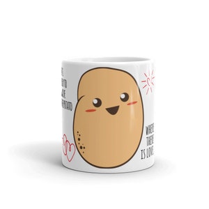 May include: White ceramic mug with a cartoon potato illustration. The potato has a smiling face and red cheeks. The text "Where there is love" is printed on the mug.