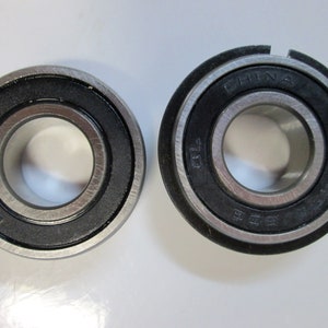 May include: Two black and silver ball bearings with the text "CHINA" and "6201" printed on the outer ring of one bearing.