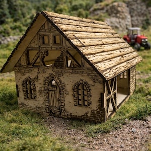 Peut inclure: Maquette en bois découpée au laser d'un bâtiment rustique, avec le texte "LaserCut Scheune" en haut. Le modèle présente des détails de maçonnerie, des fenêtres cintrées et un toit en pente. Le bâtiment est situé dans un champ herbeux.