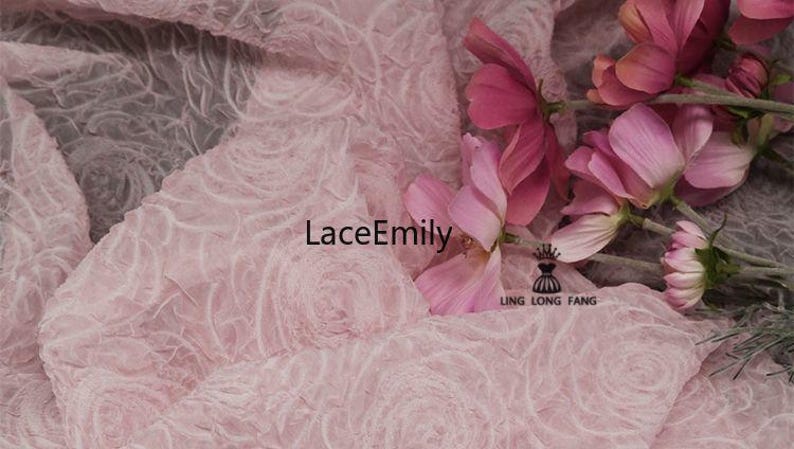 Puede incluir: Primer plano de tela de encaje rosa con un patr&oacute;n de rosas. La tela est&aacute; drapeada y tiene un aspecto delicado y texturizado. Flores rosas est&aacute;n dispuestas sobre la tela. El texto "LaceEmily" es visible.