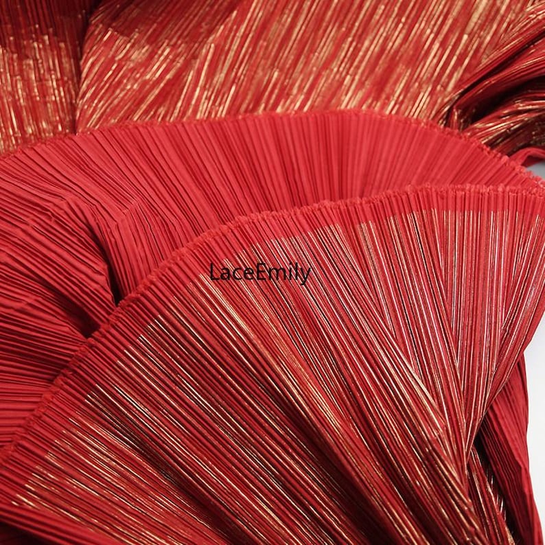 May include: Close-up of red pleated fabric with gold metallic threads. The fabric has a textured, fan-like appearance. The text "LaceEmily" is visible in the lower center of the image. This fabric is suitable for clothing and craft projects.