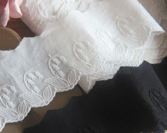 Peut inclure: Garniture en dentelle de coton blanche avec un motif floral brodé. La dentelle est délicate et a un bord festonné.
