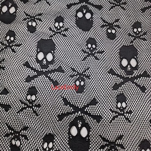 Puede incluir: Patrón de calaveras y huesos cruzados en blanco y negro. El diseño presenta un patrón repetido de calaveras y huesos cruzados negros sobre un fondo de malla blanca. Las calaveras tienen grandes cuencas oculares y están rodeadas por una fina red.