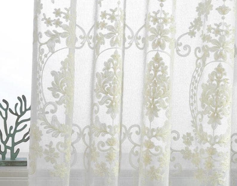 May include: White sheer curtains with an embroidered floral pattern.