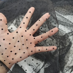 以下が含まれることがあります： 小さな黒い水玉模様の黒い透き通った生地。生地は柔らかく繊細で、クラフトや縫製プロジェクトに最適です。