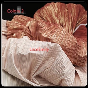 May include: Close-up of pleated fabric in shades of beige, rose, and copper. The fabric has a textured, ridged appearance. The text "Colors 2" and "LaceEmily" are visible on the fabric.