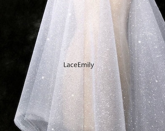 Op de afbeelding: Witte tule bruids sluier met een glinsterende, glitterende afwerking. De sluier is doorschijnend en heeft een delicate textuur. De tekst "LaceEmily" is op de sluier gedrukt.