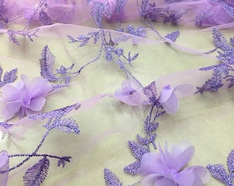 May include: Purple floral lace fabric with 3D flowers. The fabric has a delicate, sheer texture and is perfect for adding a touch of elegance to any project.