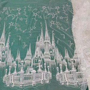 Könnte beinhalten: Weißer, bestickter Tüllstoff mit einem Schlossdesign und Sternen. Das Schloss ist mit komplizierten Designs verziert und die Sterne sind über den Stoff verteilt.